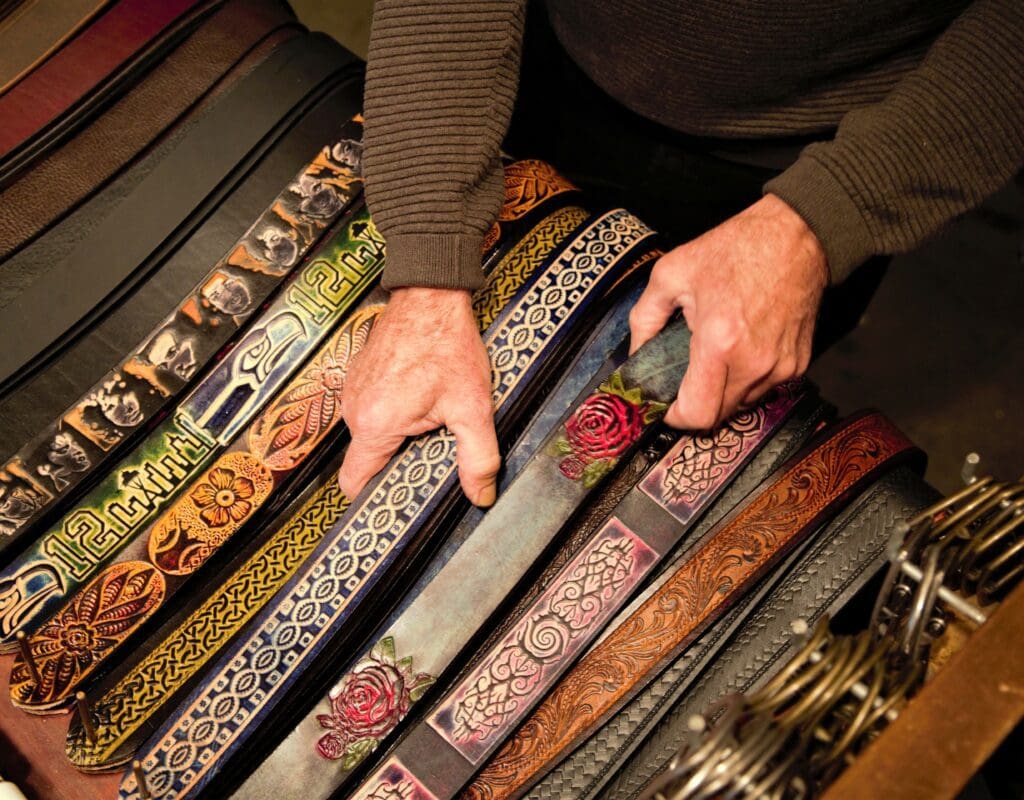 showing a colorful assortment of tooled leather belts